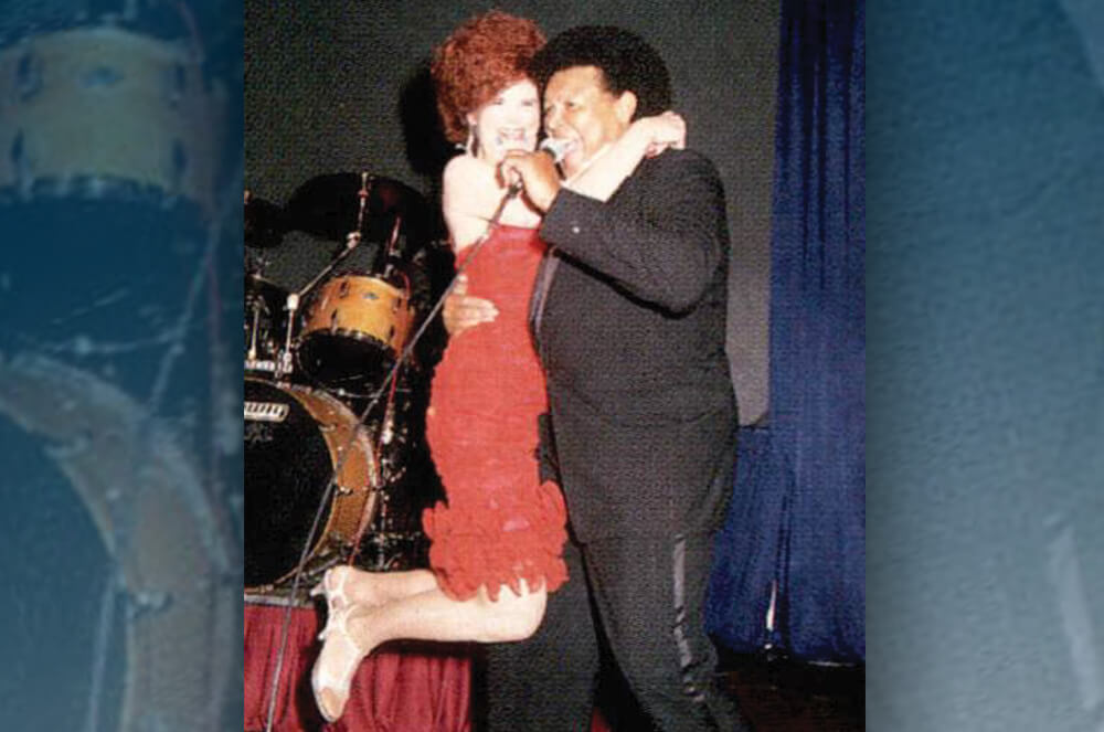 Man holding up woman in red dress on dance floor