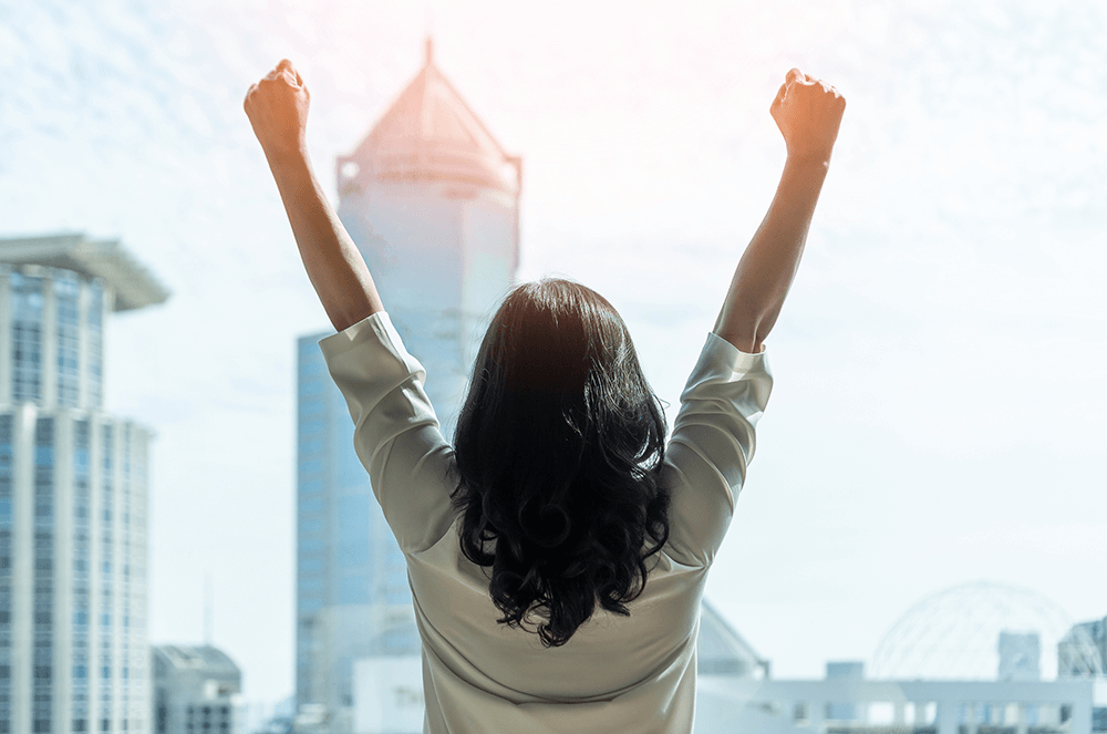 Woman facing away with hands in air