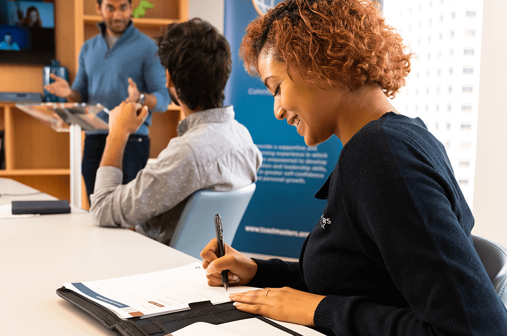 Woman smiling while writing on evaluation form