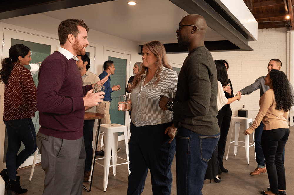 Large group of people talking to each other at open house