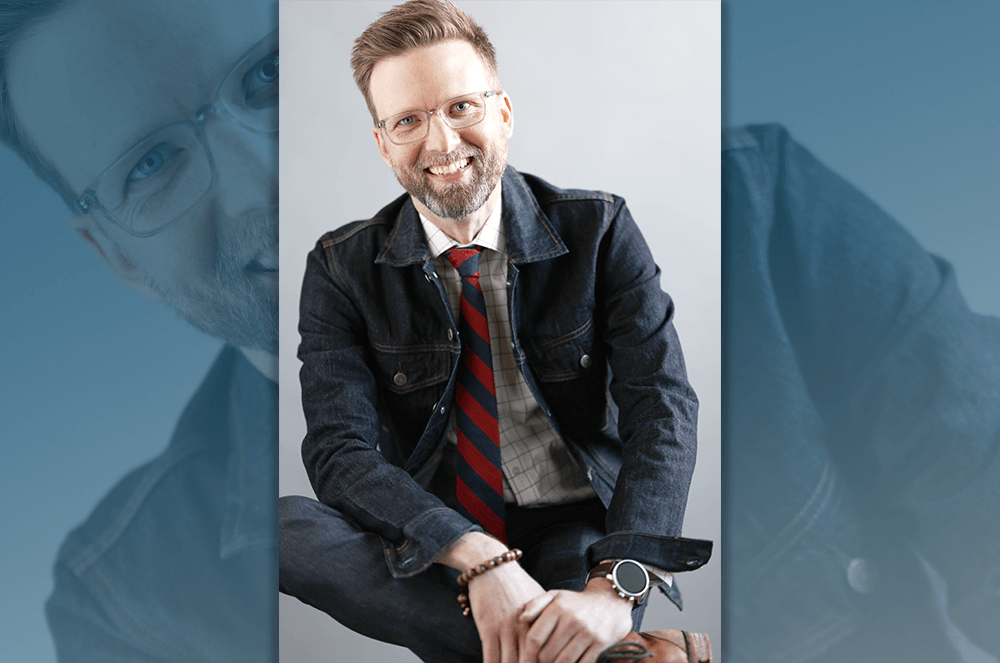 2024 convention keynote speaker Shawn Ellis smiling in jeans jacket and striped red and blue tie