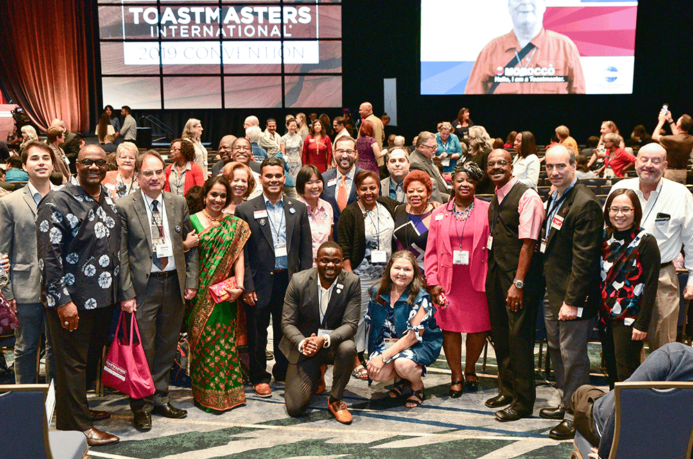 Large group of people posing wearing cultural garb at Toastmasters International Convention