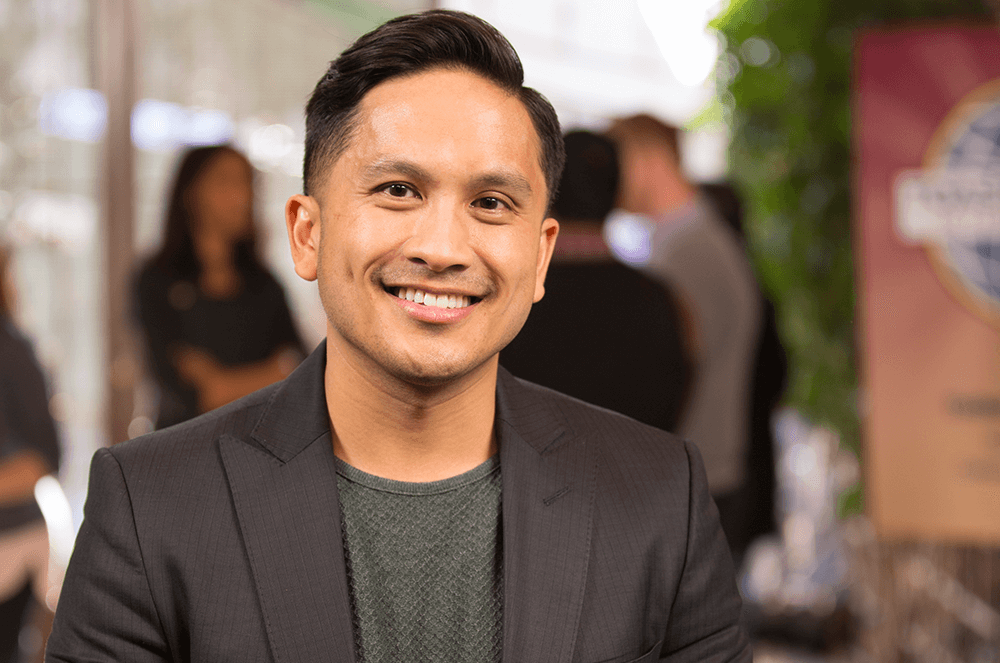 Man in suit jacket smiling at Toastmasters event