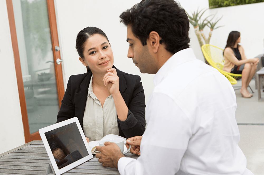 Man and woman sitting together working on iPad