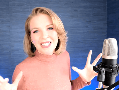 Woman in pink sweater standing in front of microphone