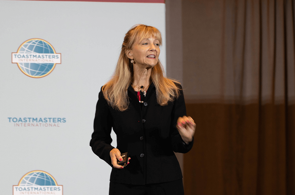 Woman in black suit speaking onstage