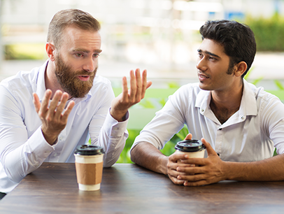 Two men speaking over coffee