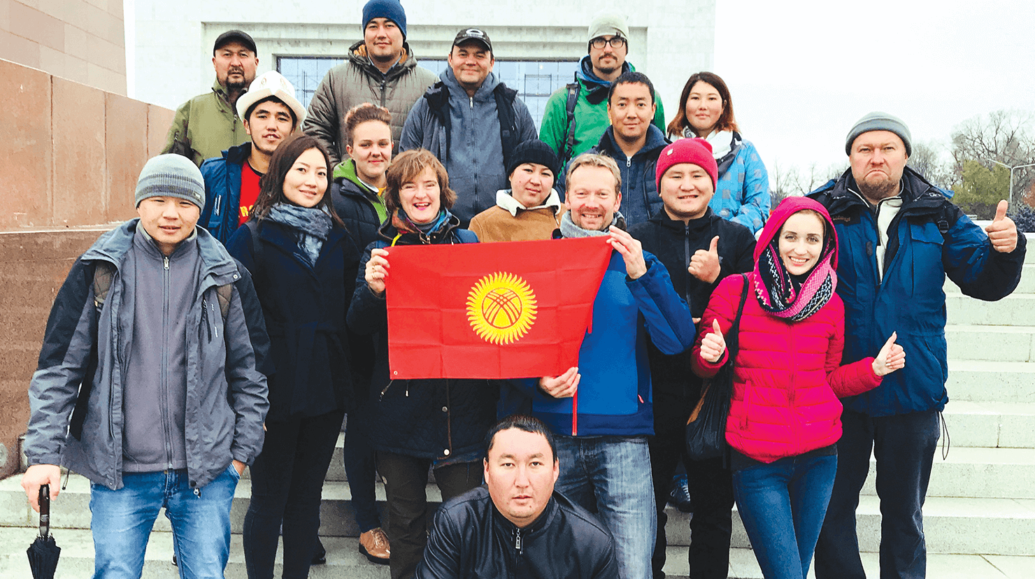 Instructors from the tour-guide training company EastguidesWest with a group of tourism students holding the flag of Kyrgyzstan in the capital city of Bishkek. Photo by EastguidesWest