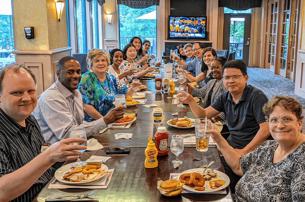 Group of people at restaurant table holding up glasses to toast