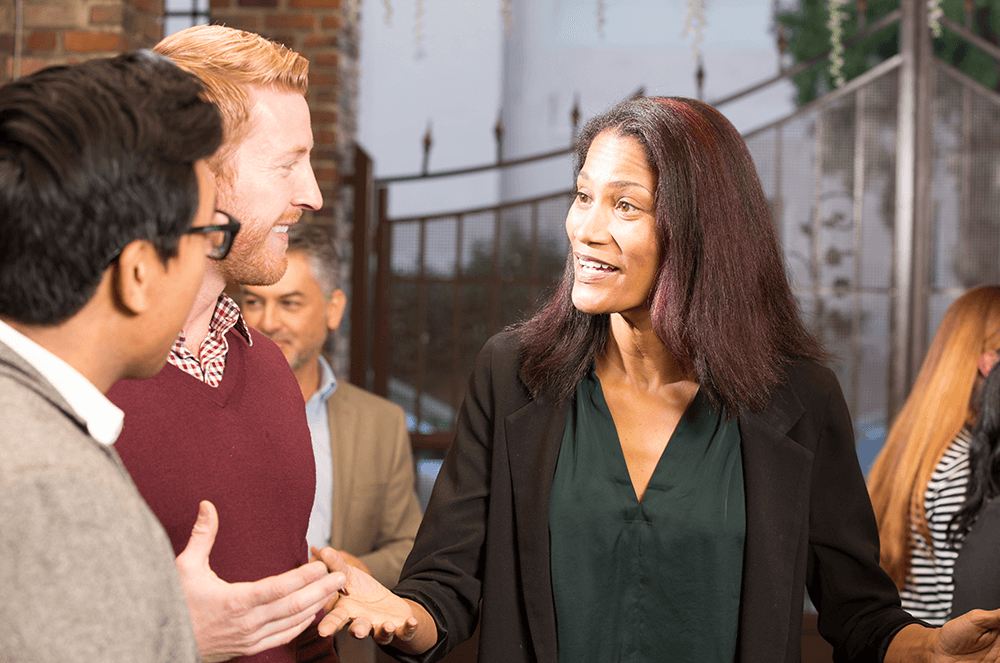 A woman wearing green shirt talking to two men