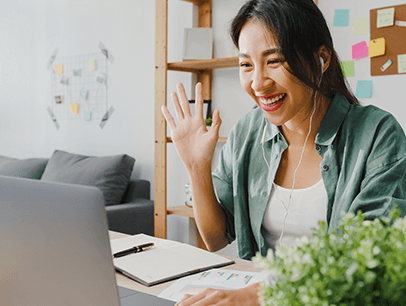 Woman waving to someone on computer video call