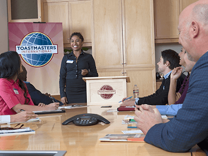 Woman standing at lectern speaking to group