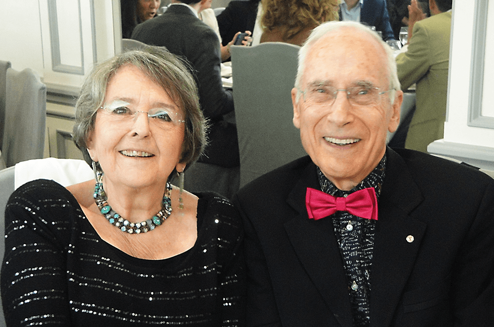 Woman and man dressed in black formal attire smiling