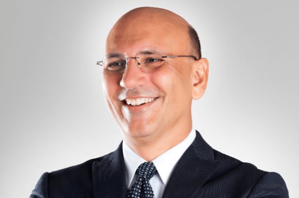 Man in glasses smiling wearing suit and tie