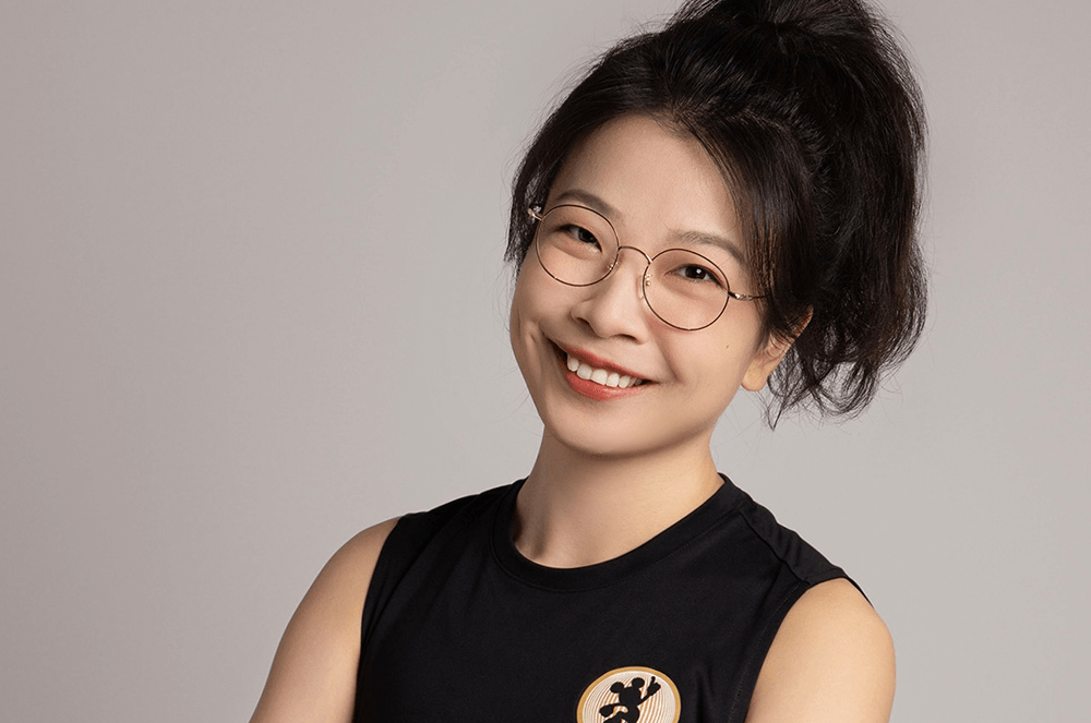 Woman in black sleeveless top posing with arms crossed