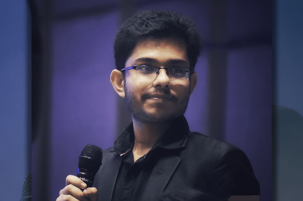 Young man in dark jacket holding microphone