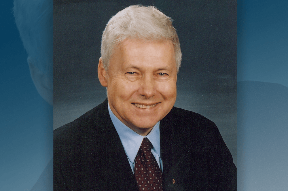 Man wearing suit and tie and smiling