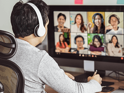 Man sitting at computer in virtual meeting wearing headphones