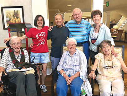 Senior citizens pose with Toastmasters volunteer