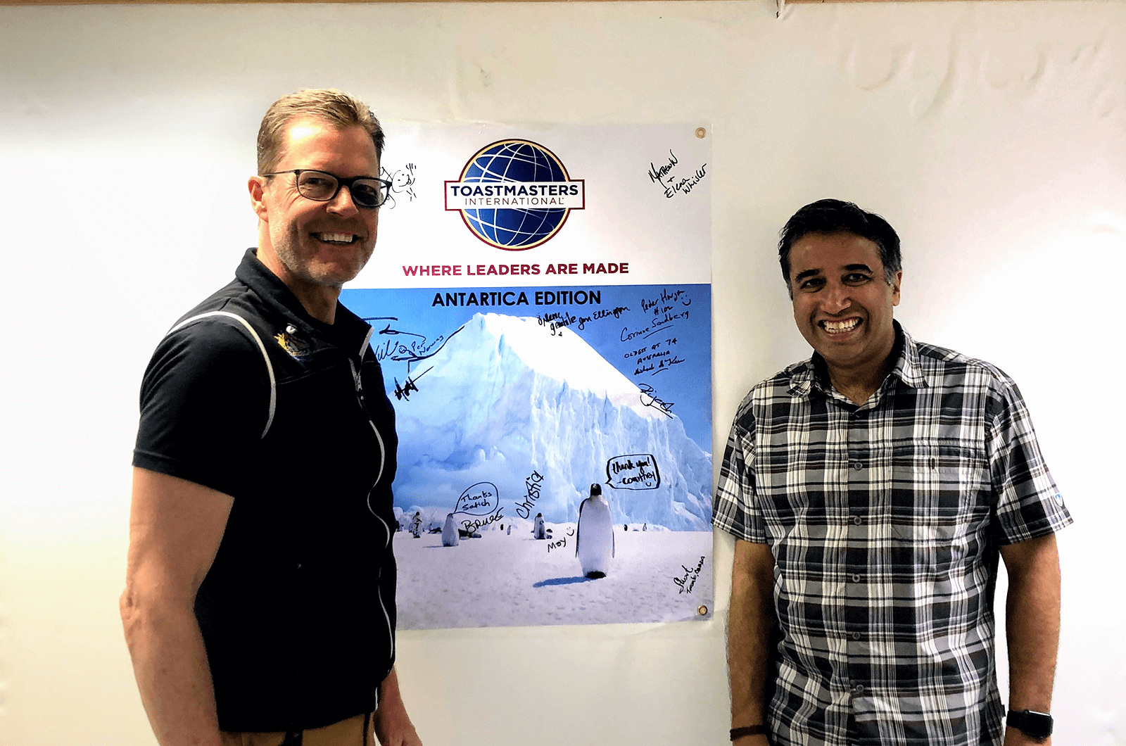 Satish (right) poses with a fellow marathon runner on the ship to Antarctica after holding a demo Toastmasters meeting.