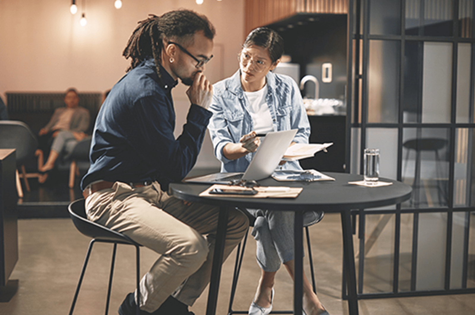 Man and woman sitting at table looking over papers