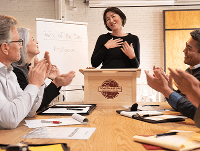 Woman standing at lectern smiling