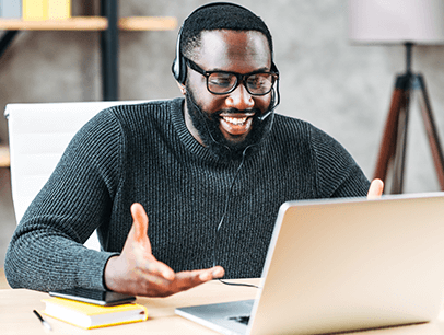 Man wearing headset talking and looking at laptop