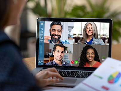 Person sitting at a desk while teleconferencing with others on screen