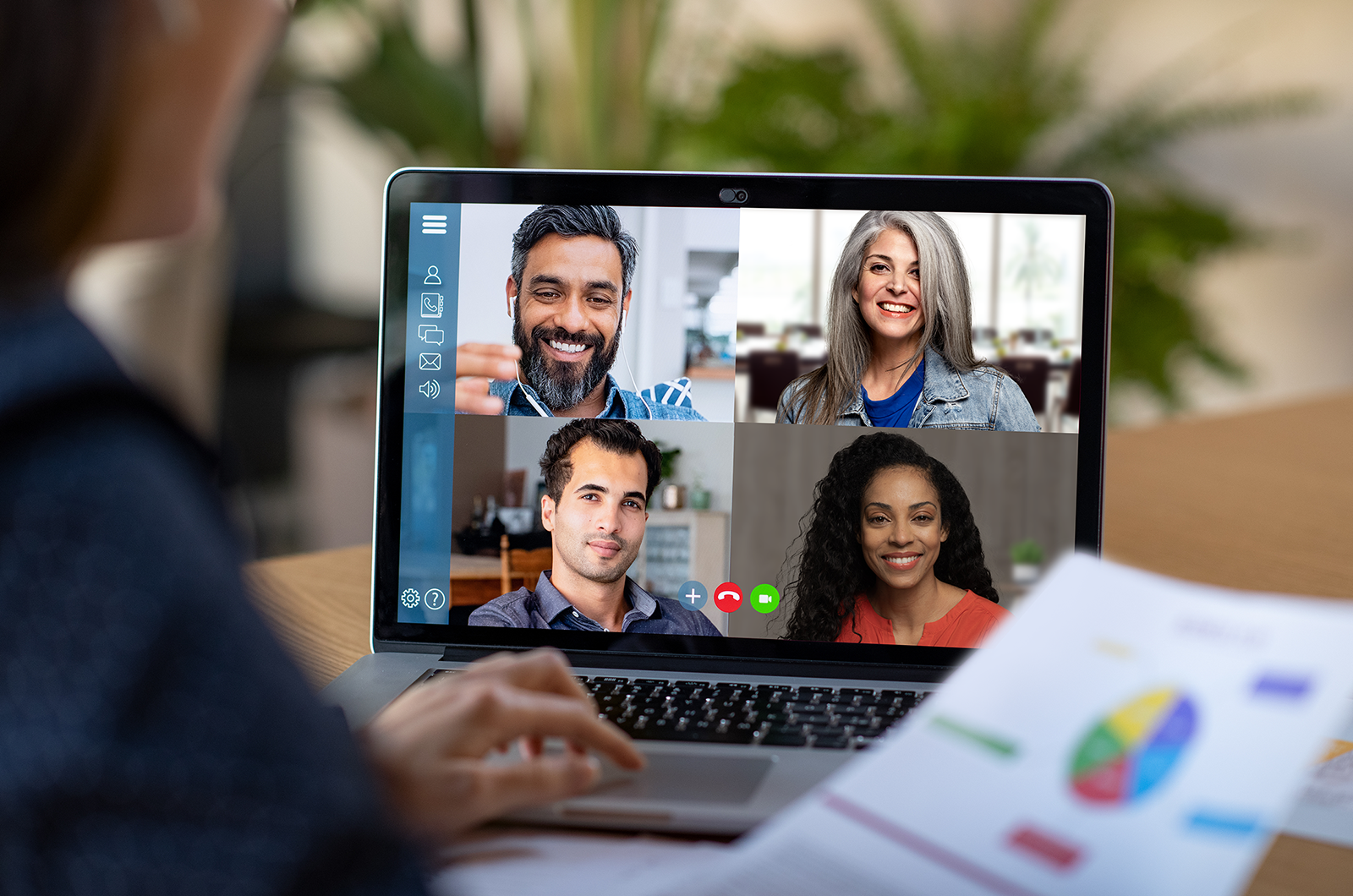 Person sitting at a desk while teleconferencing with others on screen